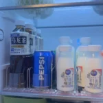 Shelf pusher helping store beverages neatly in refrigerator doors.