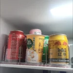 Customer using shelf pusher tracks for multiple beverage storage lanes.