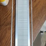 Shelf organizer rails installed inside refrigerator for beverage storage.