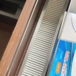 Shelf pusher system rails displayed on table including installation accessories.