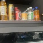 Drink pusher track system installed inside display refrigerator for soda cans.