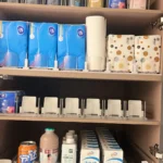 Shelf pusher system used in store beverage cooler with glass bottle drinks.